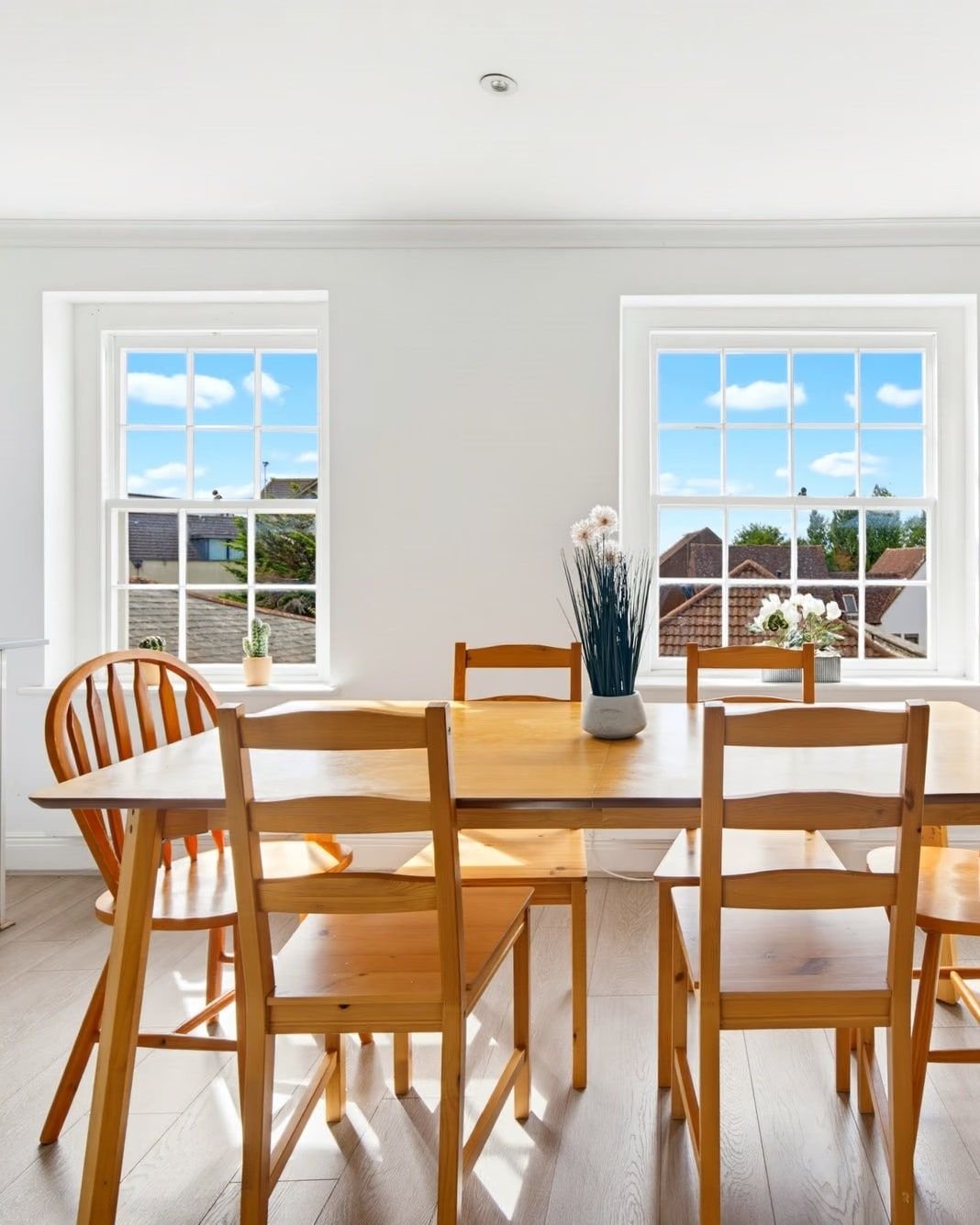 Dining table beneath two tall sash windows in a Reading flat